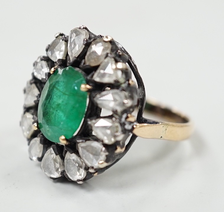An Indian yellow and white metal, emerald and rose cut diamond set oval cluster dress ring, size N, gross weight 6.3 grams.
